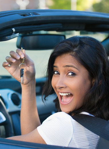 Closeup portrait, young cheerful, joyful, smiling, gorgeous woman holding up keys to her new car. Customer satisfaction